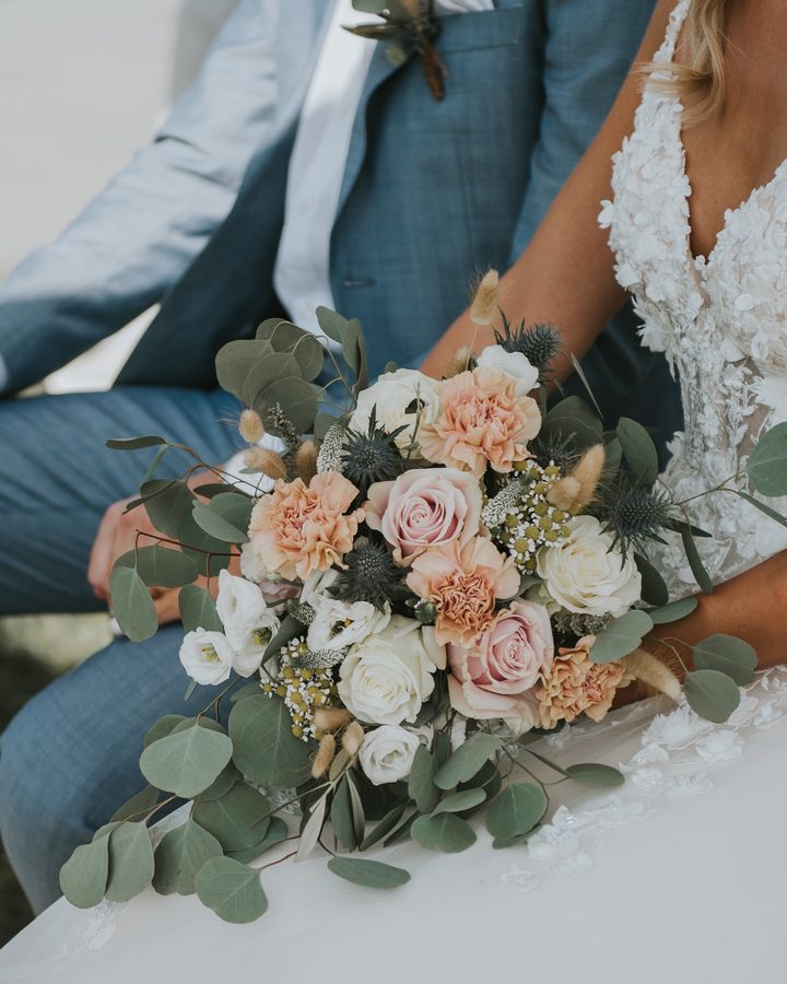 Brautpaar mit einem Strauss aus Rosen und Eukalyptus